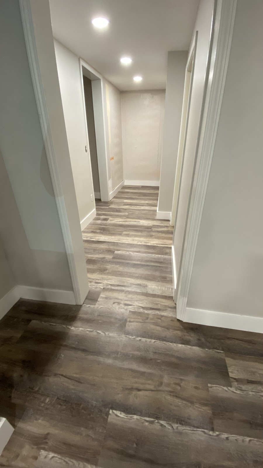 TGP Home Services — finished hallway with LVP wood-look flooring and recessed ceiling lights